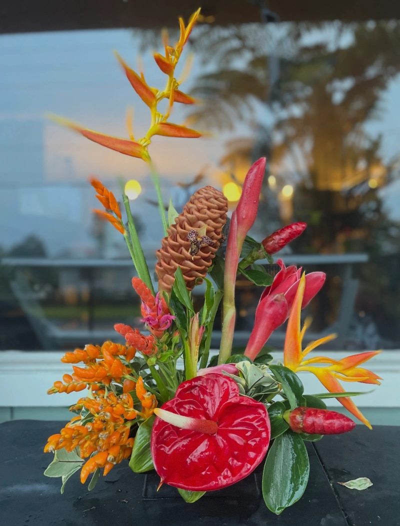 Tropical arrangement with red anthuriums, pink ginger, and orange flowers